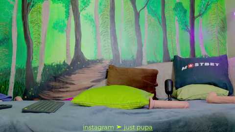 Media: Video of a bedroom with a forest-themed wall mural, featuring a laptop, pillows, and a sex toy on a bed.