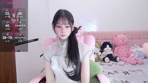 Media: A video shows a young East Asian woman with long black hair, wearing a sheer white blouse, sitting on a pink bed with stuffed animals. A TV screen displays live stream statistics in the background.