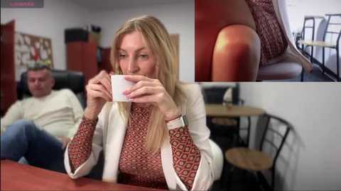 Media: A video of a blonde woman in a red-patterned sweater, drinking coffee, sitting in a modern caf\u00e9 with a man in a beige sweater in the background.