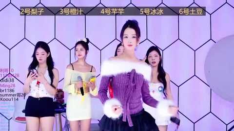 Media: Video of four Asian women in a stage setting with geometric purple and white background. One woman, center, in a purple sweater, moves dramatically.