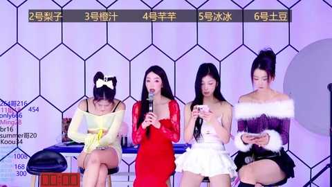 Media: Video of four young Asian women in modern, colorful outfits seated on a stage, speaking into microphones, with a digital scoreboard and audience stats visible.