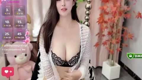 Media: Video of a young, light-skinned woman with long dark hair, wearing a revealing white lace robe over a black lace bra, posing indoors with a fake weather app overlay.