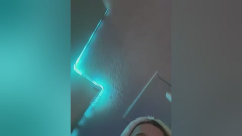 Media: Video of a close-up human nose with a blue neon glow effect, showcasing skin texture and a subtle reflection. The background is dark and blurry, emphasizing the luminous, angular light.