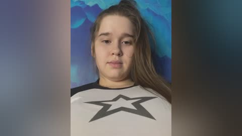 Media: A video of a young Caucasian girl with light skin and long brown hair in a ponytail, wearing a white and black Star Wars T-shirt, against a blue and purple gradient background.