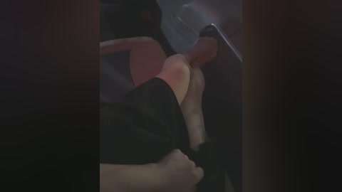 Media: A dimly-lit video shows a close-up of a man's bare legs and erect penis in a black pair of shorts. His skin is pale, and the background is blurry, focusing on the intimate scene.