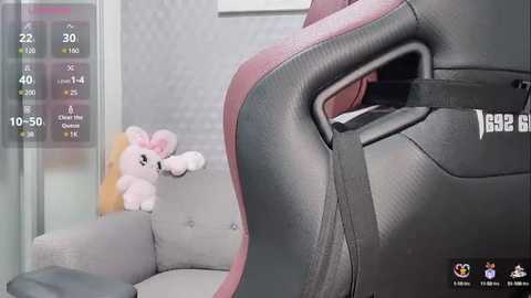 Media: Video of a pink stuffed elephant on a grey couch with a black and red gaming chair in the foreground, with a virtual reality headset overlaying the scene.