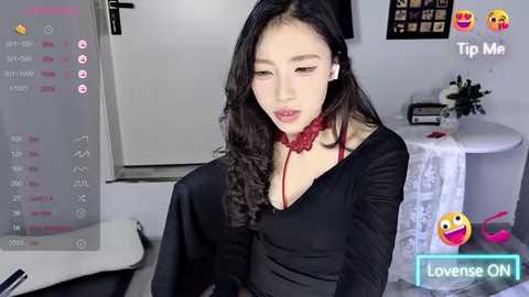 Media: Video of an Asian woman with long black hair, wearing a black dress and red choker, sitting in a modern kitchen, captioned \"Lowrise ON\" with emojis.