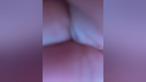 Media: The image is a blurred video featuring a close-up of a person's buttocks. The skin tone is light, and the background is a soft, muted purple hue. The overall image is out of focus, making it difficult to discern specific details.