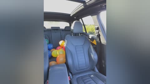 Media: Video of a modern car interior with black leather seats, a sunroof, and colorful balloons scattered on the backseat.