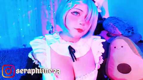 Media: Video of a pale-skinned woman with short, pastel blue hair, wearing a revealing maid outfit, holding a plush toy, in a dimly lit room with blue lighting.