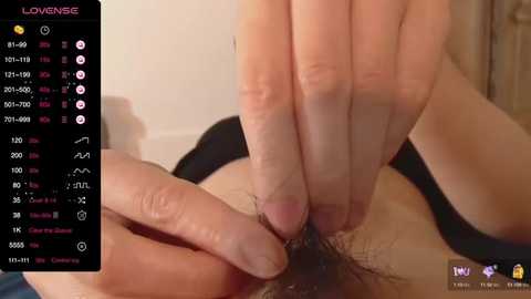 Media: Video of a close-up of a man's hand holding a woman's pubic hair. The woman's skin is fair, and her hair is trimmed. The background is a soft, blurred indoor setting.