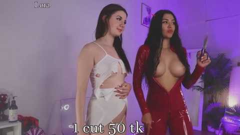 Media: Video: Two women, one in a white lace lingerie set, the other in a red latex bodysuit, standing in a dimly lit room with purple lighting.