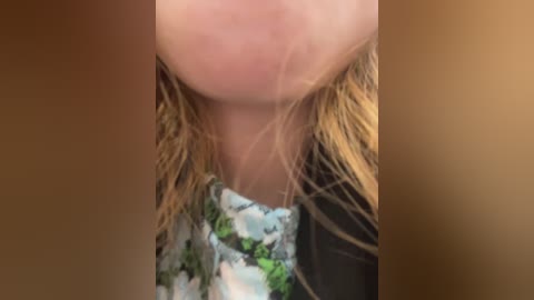 Media: A close-up video of a person with fair skin, wearing a floral-patterned top, and wet, blonde hair. The focus is on the neck and shoulders, with a blurred background.