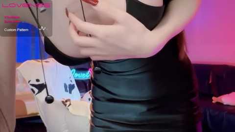 Media: A video of a pale-skinned woman with long brown hair, wearing a tight, black latex dress, standing in a dimly lit room with purple and blue lights.