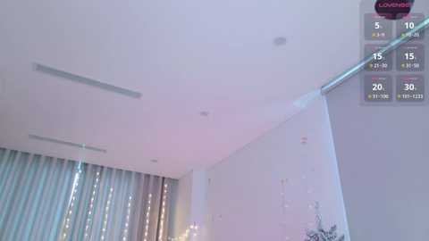 Media: Video of a modern, minimalist bedroom with a white ceiling, silver curtain, and a silver chandelier; a digital timer with numbers 5, 15, 20, and 30 is displayed in the top right corner.