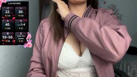 Media: Video of a light-skinned woman with long brown hair, wearing a pink jacket over a white lace bra, with a \"LoveNGG\" profile overlay showing 10-50% progress.