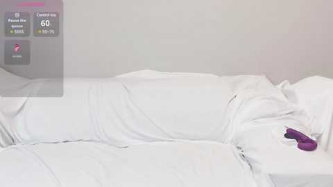 Media: A video of a white bed with smooth, pristine bedding. A purple vibrator is partially visible on the right side, and a digital health app interface is overlaid on the left, displaying statistics.