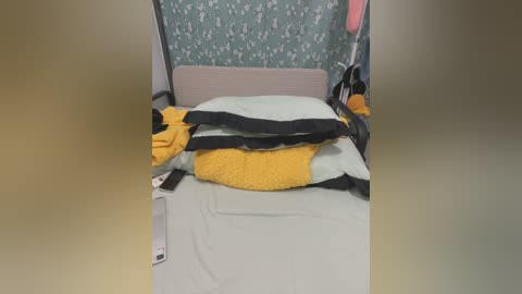 Media: A video of a hospital bed with a plush bee toy and a white blanket, against a patterned green wall.