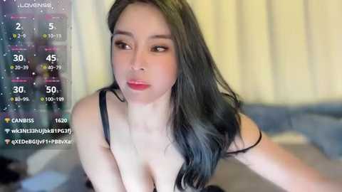 Media: A video of an Asian woman with long black hair, wearing a black bra, in a dimly lit room with a virtual camera overlay showing her stats.