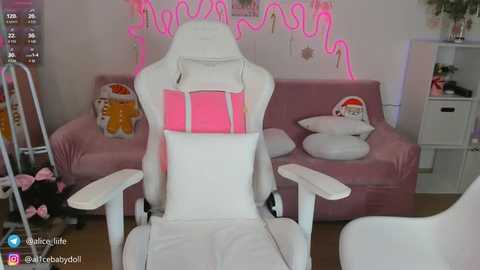 Media: Video of a plush white gaming chair with a pink neon sign backdrop, featuring plush toys and a pink sofa, creating a cozy, themed gaming room.