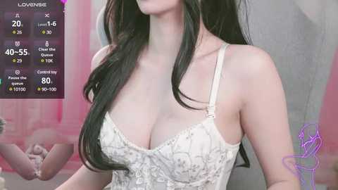 Media: Video of an East Asian woman with long black hair and pale skin, wearing a white lace bralette that accentuates her large breasts. Background shows pink and white decor, with a digital display showing stats like 20,000 subscribers and 40-50 chest size.