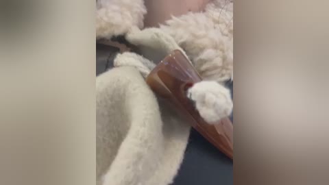 Media: A close-up video of a person's hand and arm covered in fluffy white and brown faux fur, possibly for a costume, with blurred background.