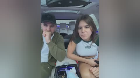 Media: Video of a young couple in a car, man in a hat and green jacket, woman in white top and shorts, looking upset.