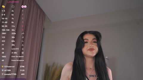 Media: Video of a young woman with long black hair, fair skin, and makeup, smiling in a dimly lit room. Text overlays show her statistics and social media details.