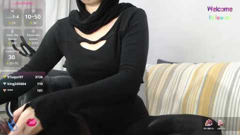 Media: Video of a woman in black clothes, scarf, and a striped pillow. Background includes a digital text overlay with \"Welcome\" and \"Hello\" messages.