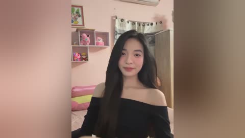 Media: Video of a smiling Asian woman with long black hair, wearing an off-shoulder black top, in a pink bedroom with My Little Pony-themed decor.