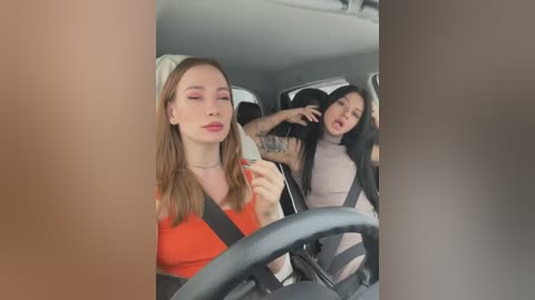 Media: Video: Two young women, one with light skin and long red hair, the other with darker skin and black hair, in a car, laughing, wearing casual clothes.