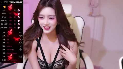 Media: Video of an Asian woman with long brown hair, wearing black lace lingerie, smiling in a modern, well-lit room.