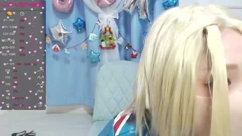 Media: Video of a young blonde girl wearing a blue Elsa dress, in a colorful, star-themed room with a chat window on the left.