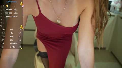 Media: A video of a woman in a tight, low-cut, red dress, leaning forward. She has long brown hair, fair skin, and a slim figure. The background shows a blurred living room.