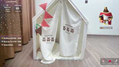 Media: Video of a white, triangular tent with red triangular flaps, filled with white fabric bags, against a light gray wall with a Lego advertisement.