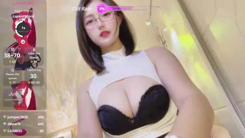 Media: Video of a young Asian woman with straight black hair, glasses, and a revealing black lace bra, posing in a bathroom.