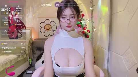 Media: Video of a young Asian woman with glasses and a high-collared, revealing white top, sitting in a colorful room with a large smiley face and toy figurines.