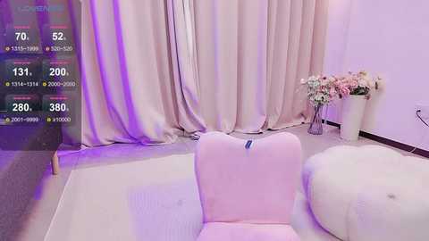 Media: A video of a minimalist, pastel-toned room with a soft pink chair and white cushion, beige curtains, a floral arrangement, and a plush white rug, bathed in purple lighting.