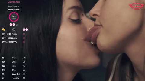 Media: Video of two women, one with black hair, kissing passionately. Background shows a virtual dating platform interface with user names, age, and location.