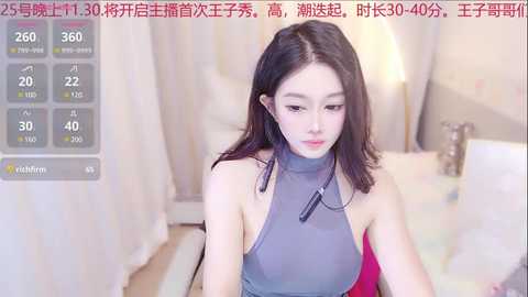 Media: A video of an East Asian woman with long black hair in a gray sleeveless dress, sitting in a softly lit room. Chinese text overlays the image.