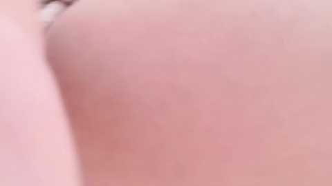 Media: A close-up video of a person's bare buttocks, focusing on the smooth, light-skinned texture. The image lacks distinct features, emphasizing the skin tone and slight shadows.