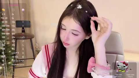 Media: A video of an Asian woman with long black hair, wearing a sailor uniform, adjusting her hair in a chair. Background includes a Christmas tree and calendar.