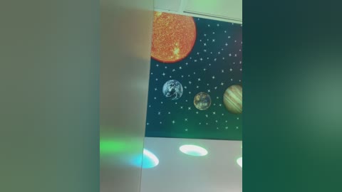 Media: A video of a classroom wall adorned with a colorful, stylized solar system mural featuring planets and stars, with soft green and blue lighting creating a serene atmosphere.