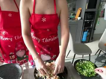 Media: Video of a person wearing a red apron with a Christmas design, mixing ground beef in a bowl, with a kitchen background featuring modern furniture and appliances.