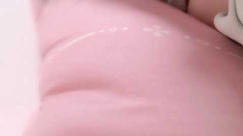 Media: Close-up video of a person's smooth, light pink skin with faint stretch marks, possibly on their back or buttocks. The background is blurred and white.