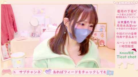 Media: A video of an Asian woman in a pastel room, wearing a light green hoodie and a blue mask, with a caption in Japanese.