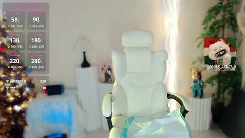 Media: A video of a white gaming chair in a well-lit, modern living room with a Christmas tree, a potted plant, and a TV screen displaying a game.