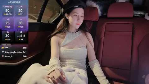 Media: Video of a young Asian woman in a black beret, wearing a white, one-shoulder, long-sleeve dress, sitting in a red car at night.