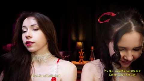 Media: Video of two young women with long dark hair, one with a dainty lace choker, in a dimly-lit, romantic setting.