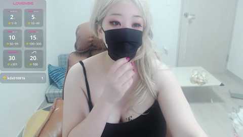 Media: A video shows a blonde woman in a black mask and tank top, sitting in a white room with a chart displaying location data.